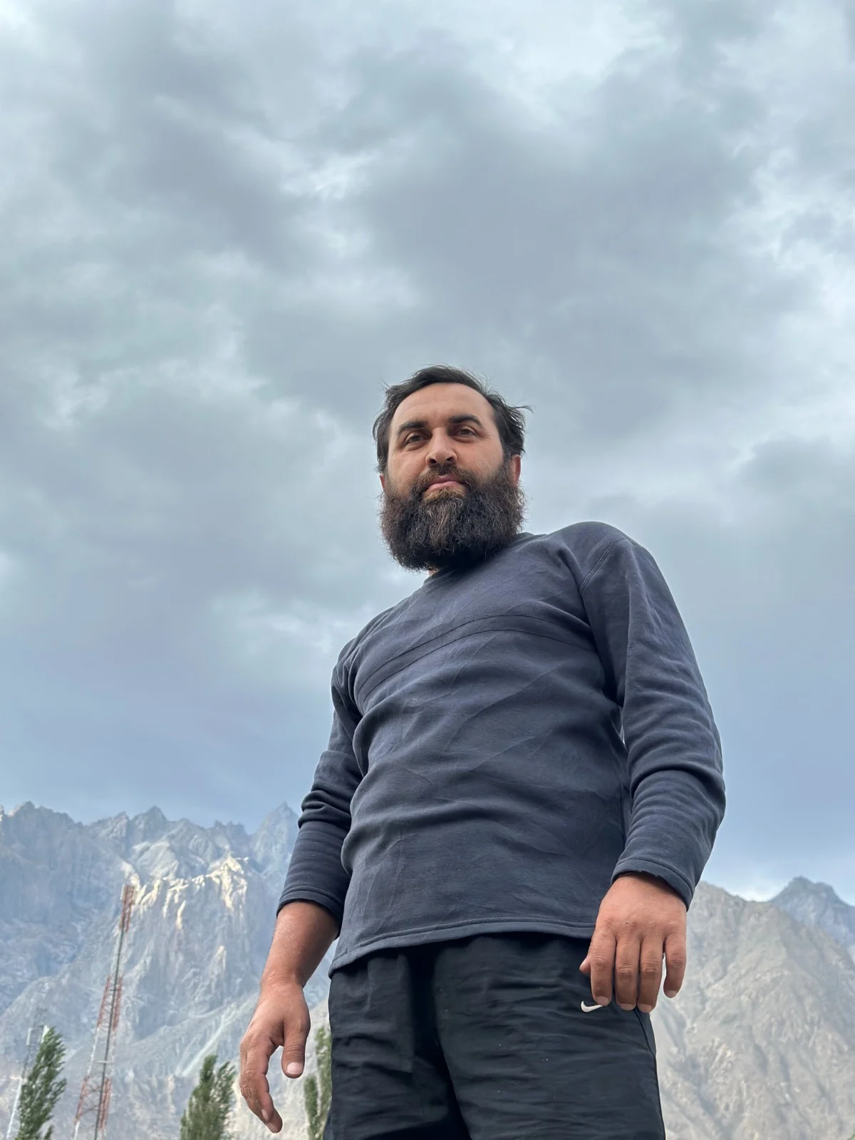 A low-angle portrait of Abdullah under soft clouds
